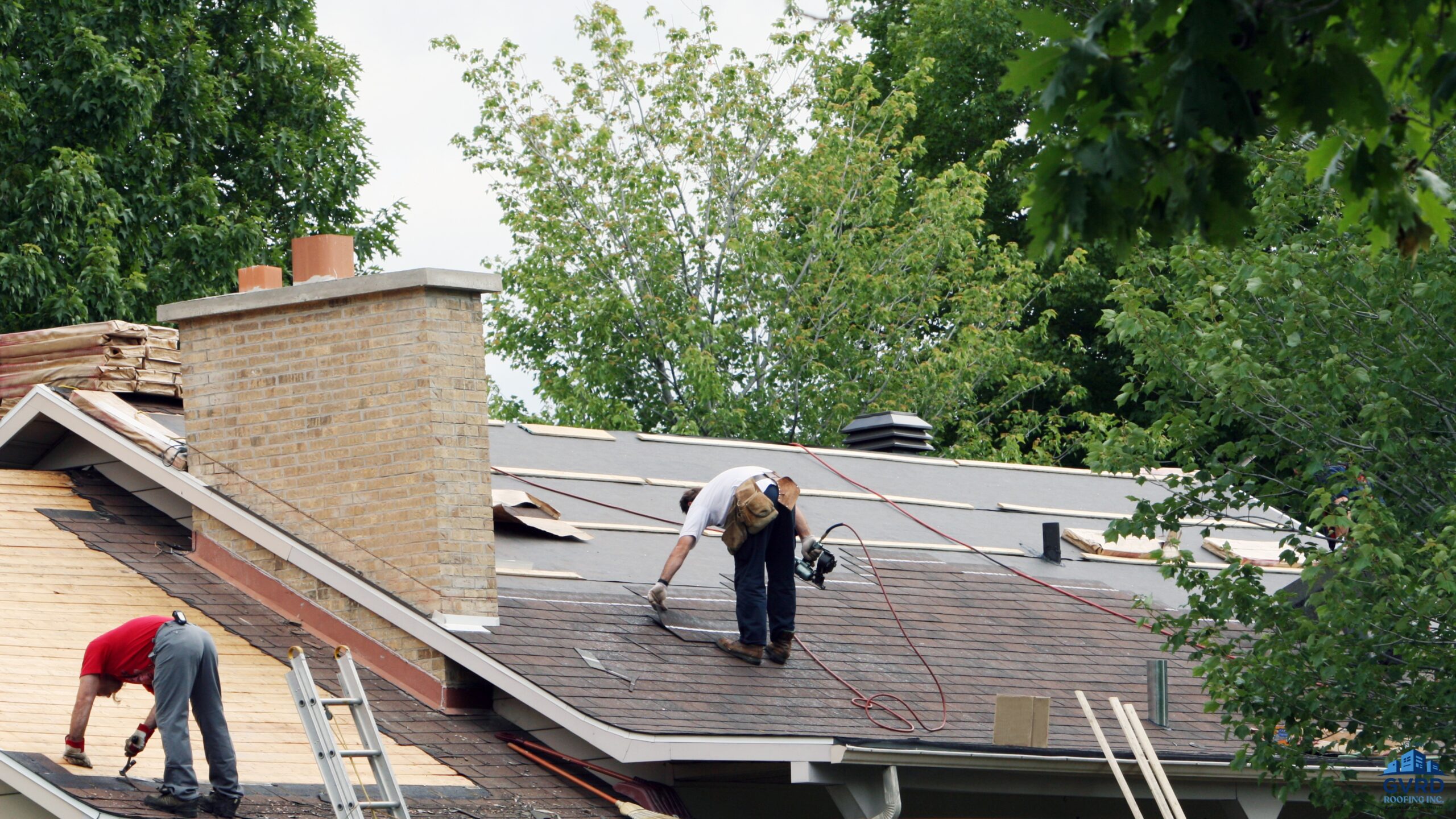 Roofing crew removing old shingles and installing new roofing on a residential home.