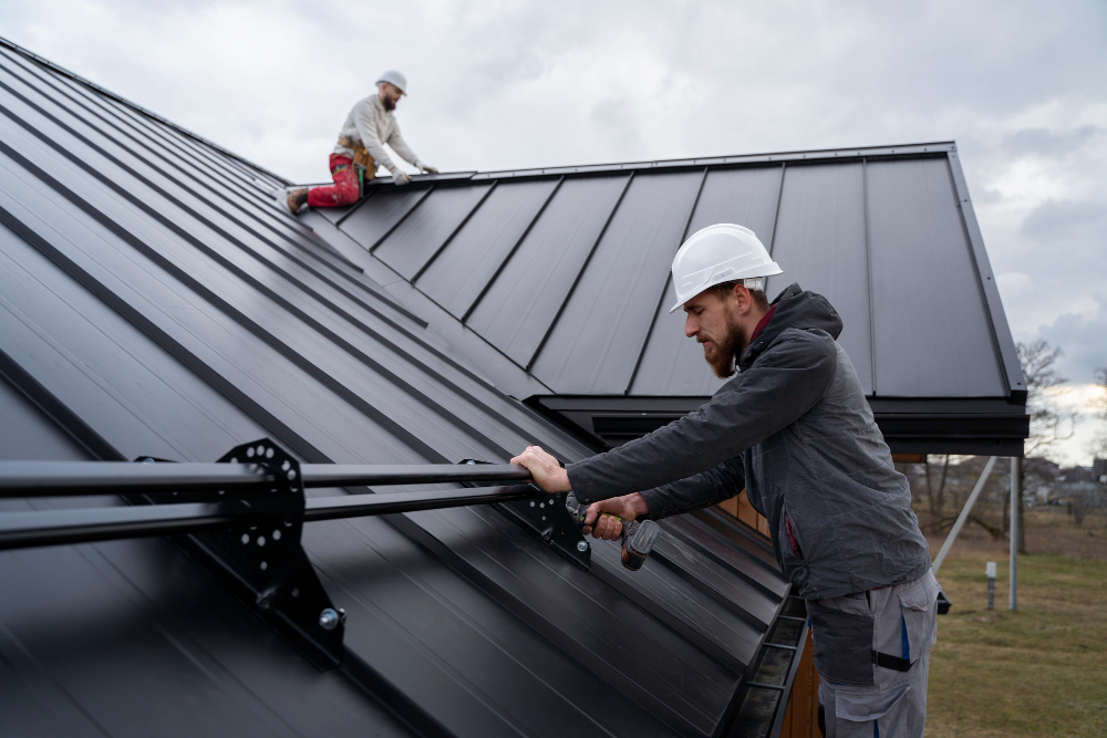 Roofing crew installing metal panels on a residential roof in Vancouver.